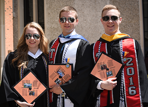 Many graduates, like this trio, decorated their mortar boards for graduation.